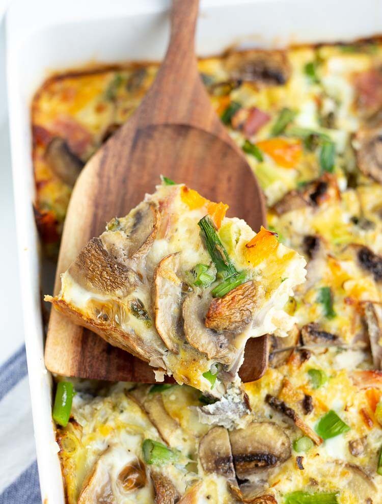 Everything but the Fridge Frittata-6 Image of Everything but the Fridge Frittata in a white dish with a single serving being lifted by a wooden spatula.